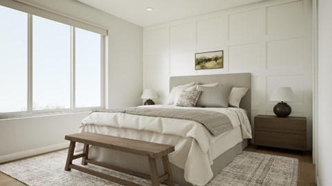 A bedroom with a large bed and a wooden bench.