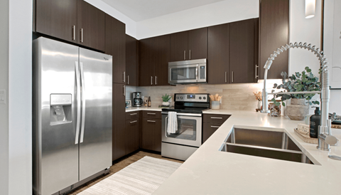 A modern kitchen with a stainless steel refrigerator and oven.