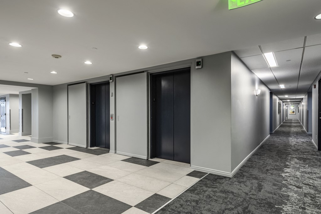 Two elevators next to a hallway