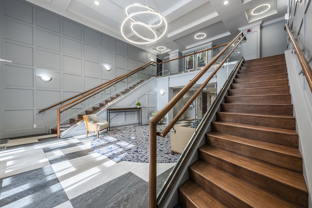 Entrance into lobby with a close up of a staircase next to a seating area
