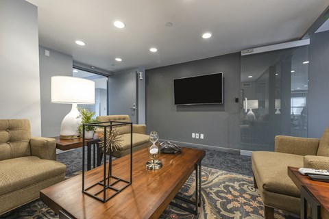 Office area with carpet flooring, seating, and a TV