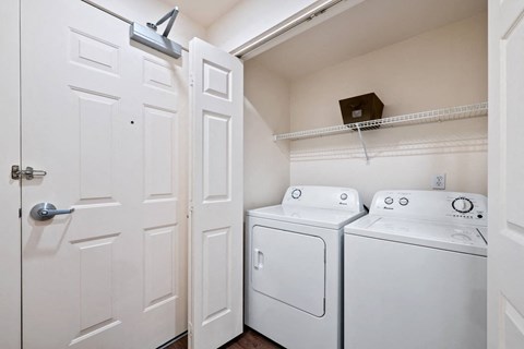 Full size washer and dryer in laundry closet with shelving