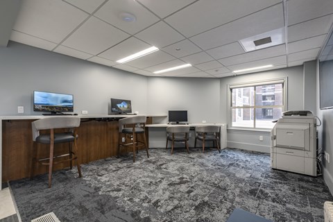 A room with a grey carpet and a large printer.