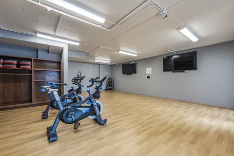 A room with a wooden floor and a stationary bike.