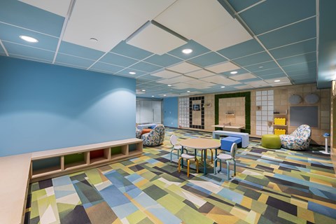 A room with a blue wall and a colorful floor.