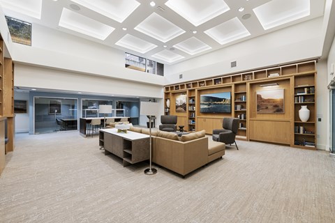 A spacious room with a carpeted floor and a bookshelf filled with books.