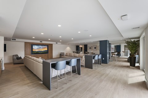 A modern living room with a large television and comfortable seating.