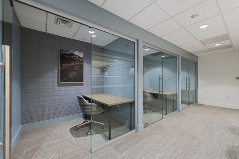 A conference room with a glass table and chairs.