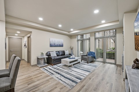 A modern living room with a grey sofa and a wooden floor.