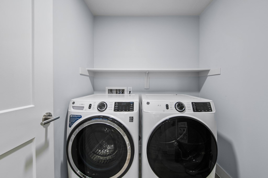 Two front load washing machines in a laundry room.