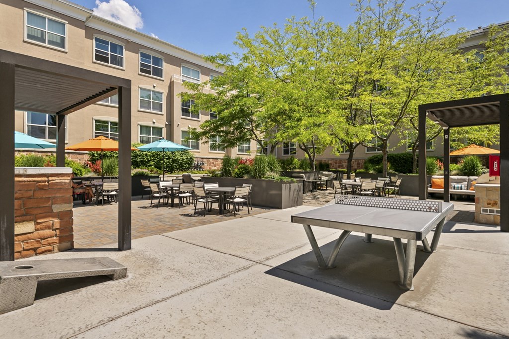 a patio with a ping pong table and a fire pit