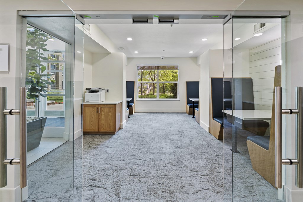 a room with glass doors and a table with a printer on it