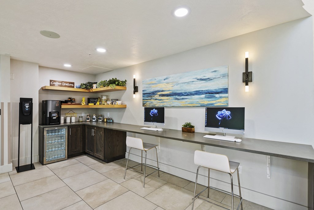 a reception desk with two white chairs and two computer monitors