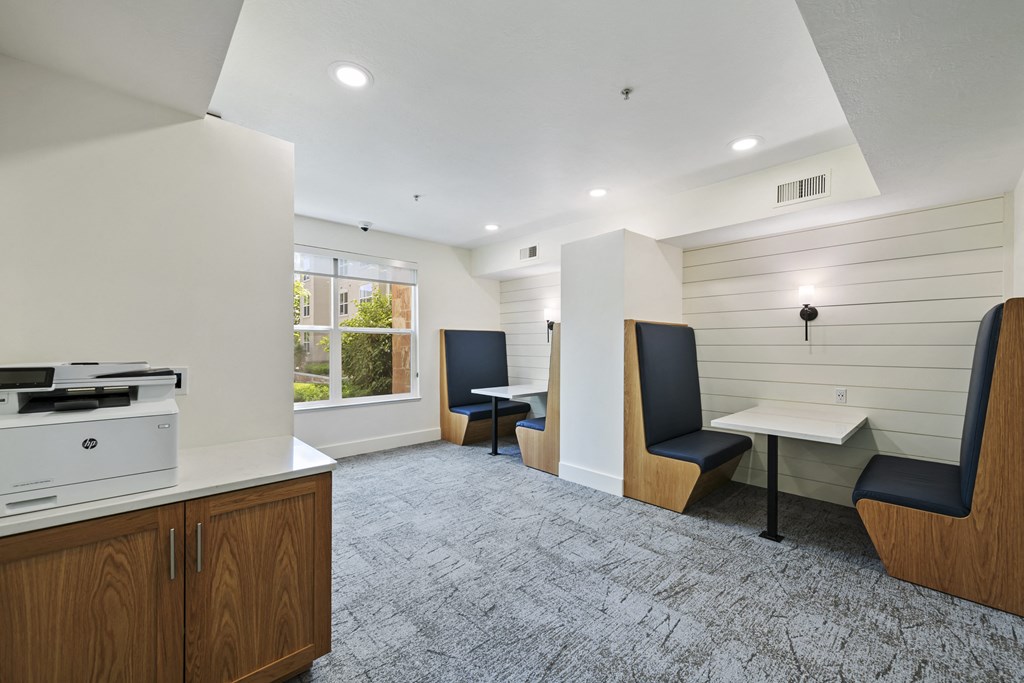 a room with a printer and two tables with chairs