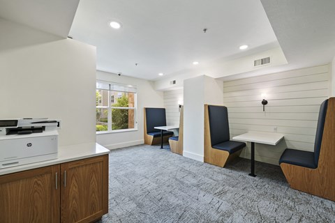 a room with a printer and two tables with chairs