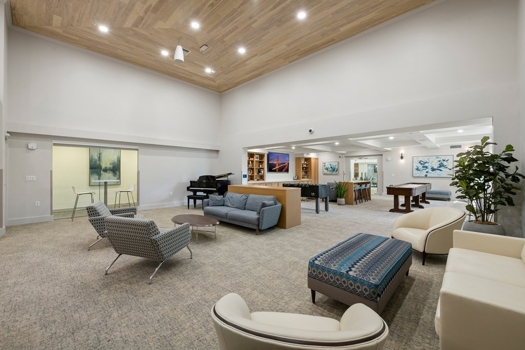 A spacious waiting room with a variety of seating options and a plant in the corner.