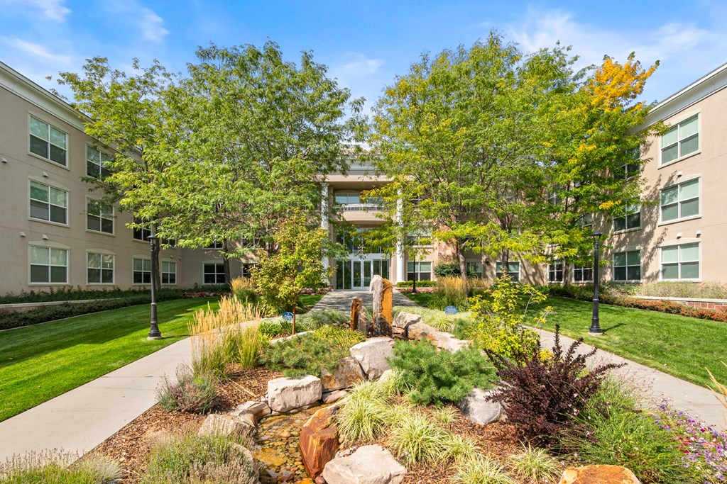 A garden with a waterfall in front of a building.