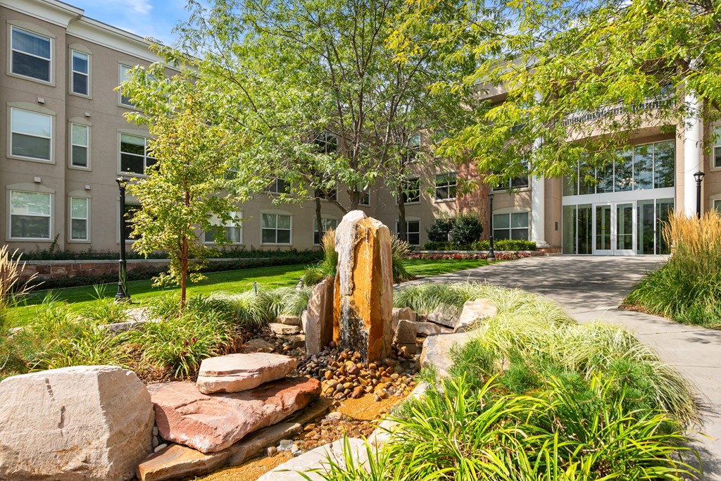 A large rock in the middle of a garden.