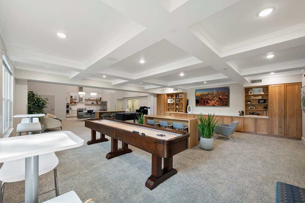 A spacious room with a pool table and a bar area.