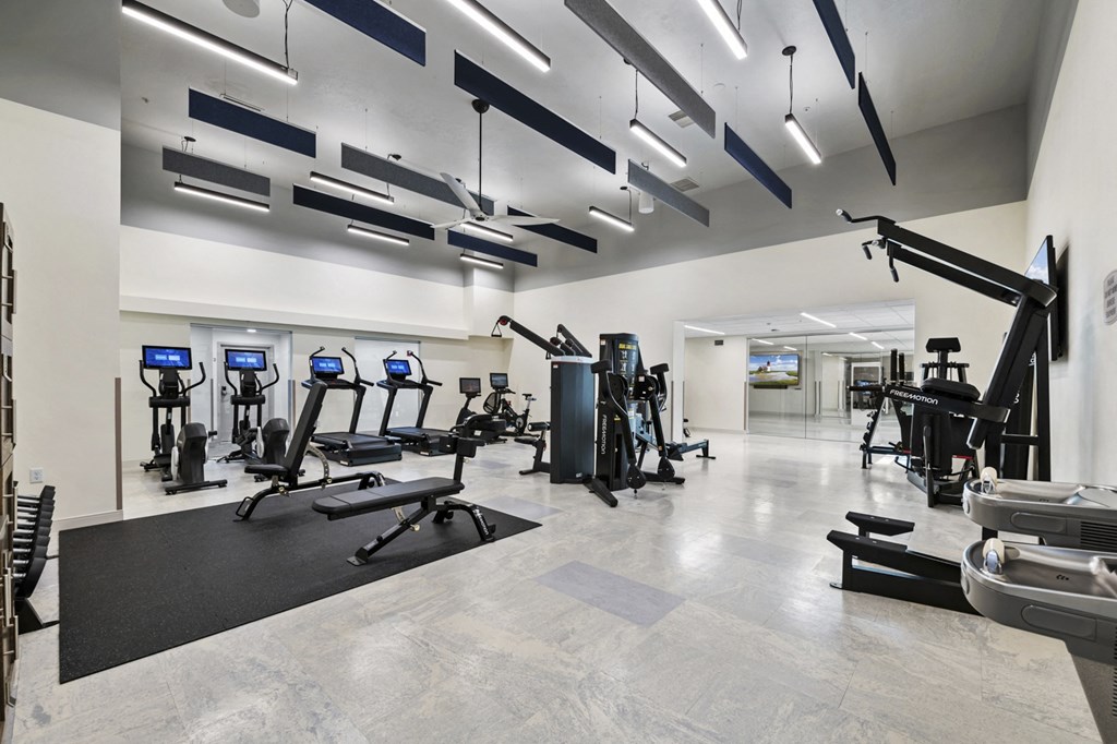 a spacious fitness room with treadmills and other exercise equipment