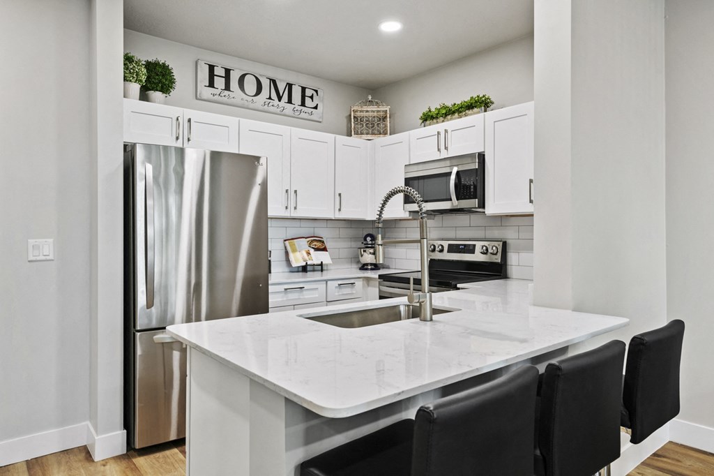 a kitchen with white cabinets and stainless steel appliances