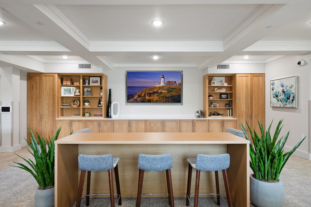 A modern kitchen with a wooden island and blue bar stools.