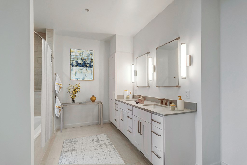 a white bathroom with two sinks and a shower