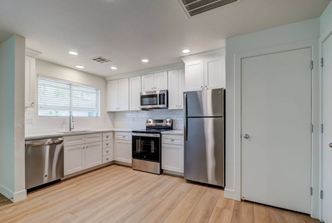 A kitchen with white cabinets and stainless steel appliances.