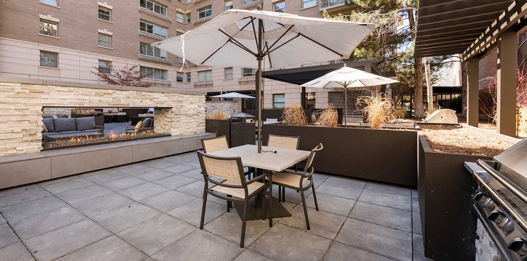 Outdoor seating area next to BBQ grill and a fireplace