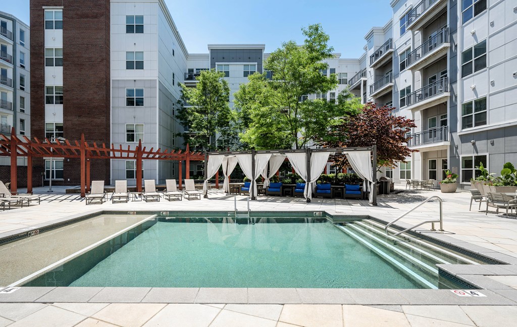 an apartment swimming pool in front of an apartment building