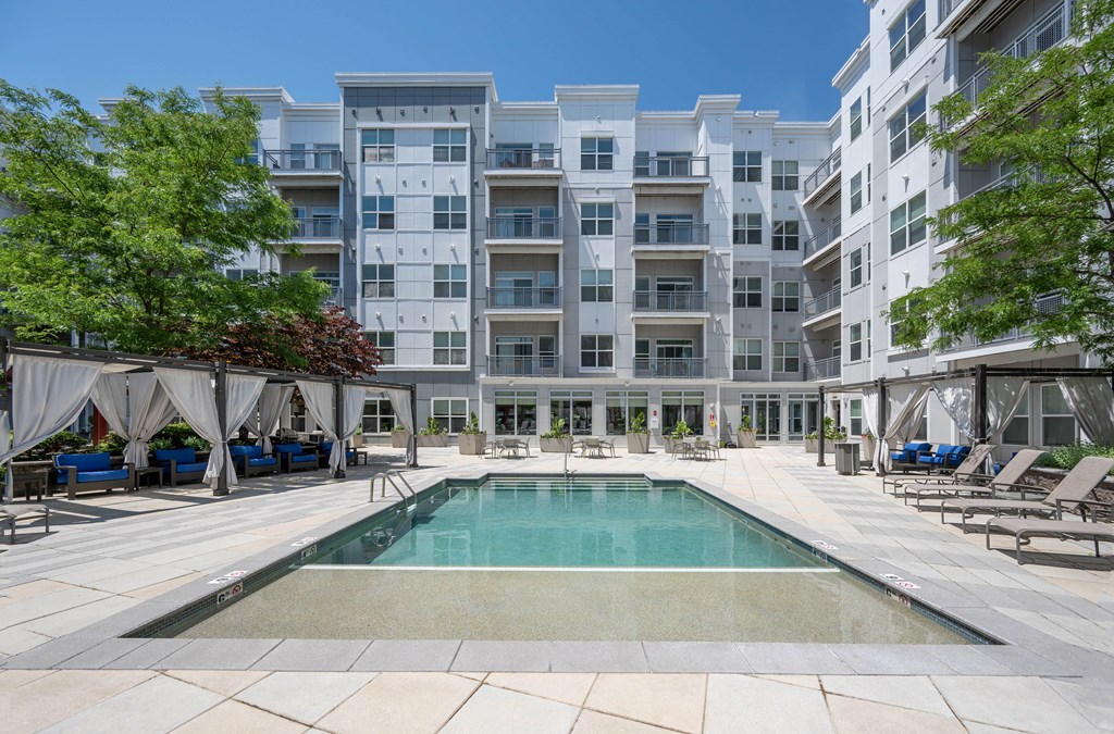 a swimming pool with an apartment building in the background
