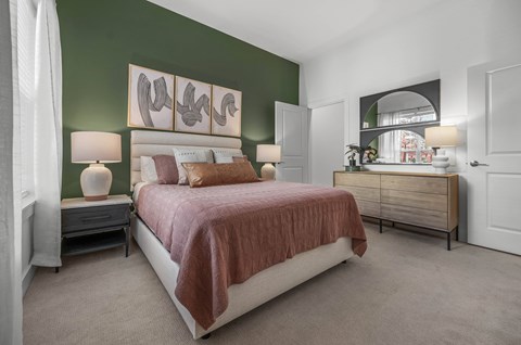 a bedroom with green walls and a bed with a brown blanket