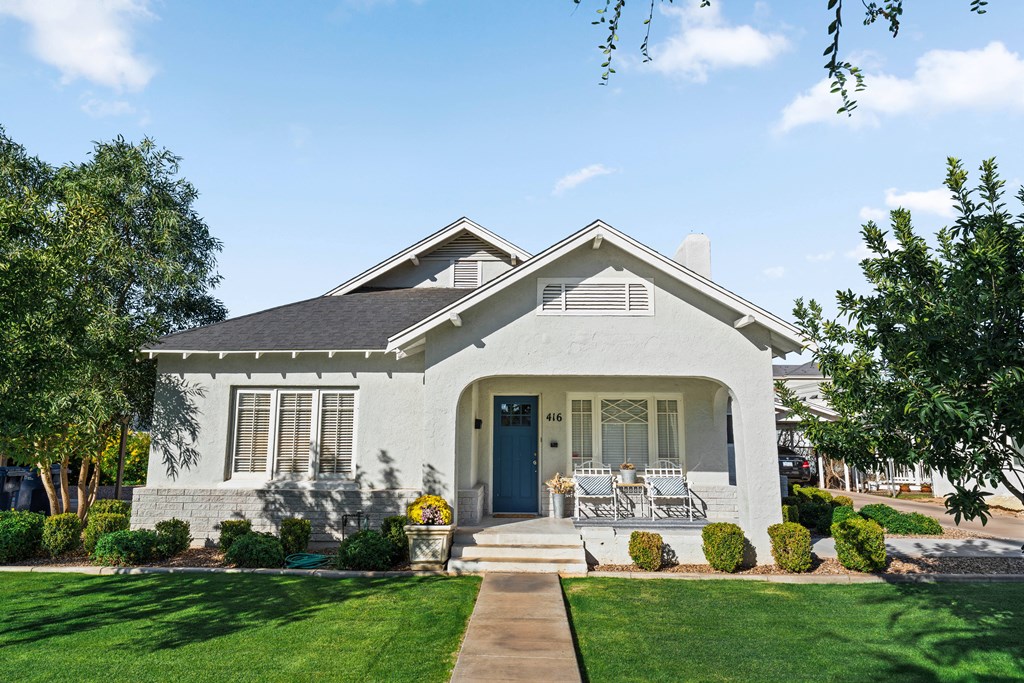 A white house with a blue door and a small porch.