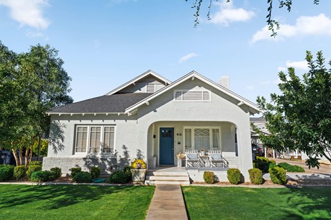 A white house with a blue door and a small porch.