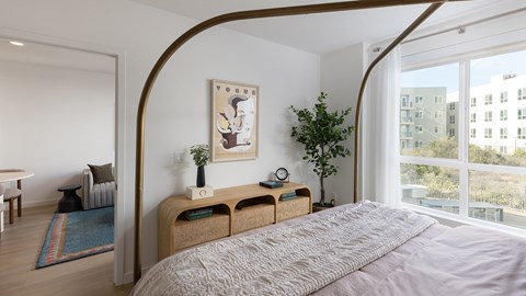 A bedroom with a large bed and a painting on the wall.