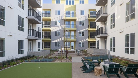 Apartment complex with a green lawn and a playground.