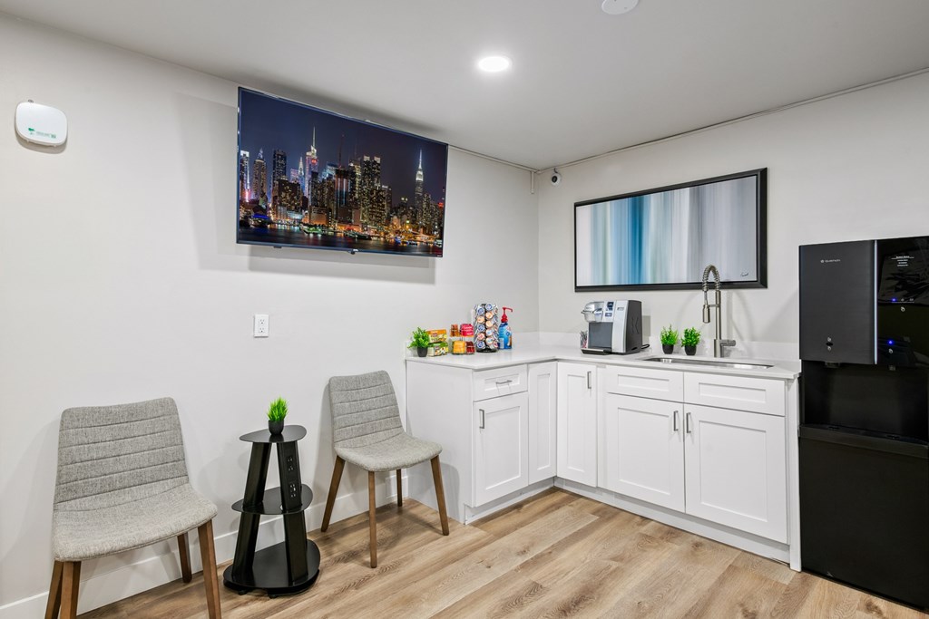 A modern kitchen with a cityscape picture on the wall.