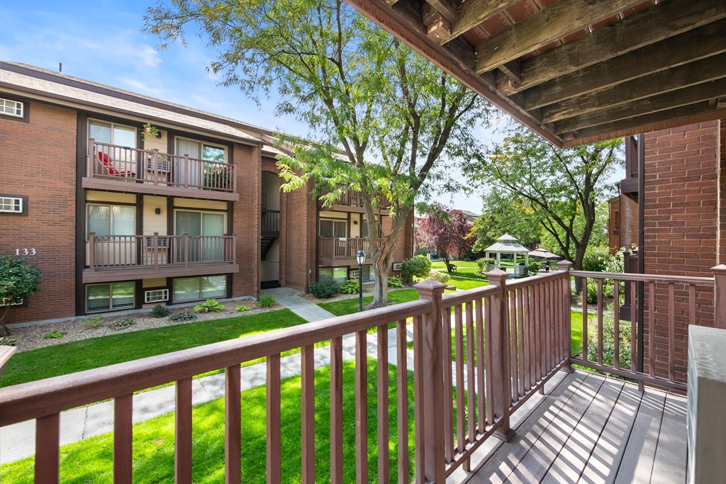 A view of a balcony with a railing and a building in the background.
