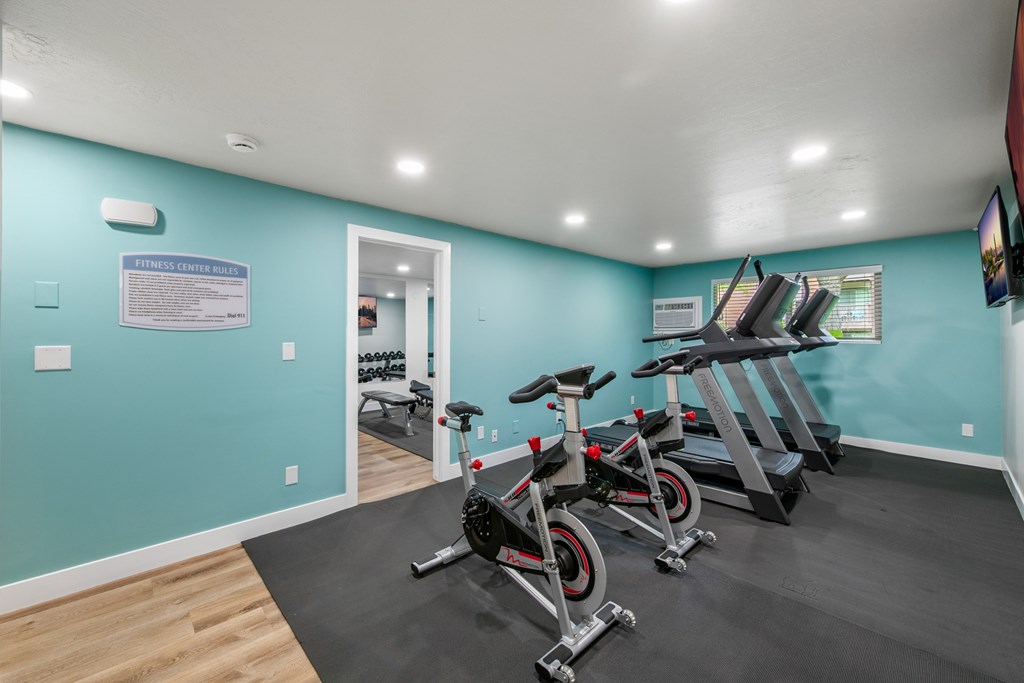 A fitness center with exercise bikes and a sign on the wall.