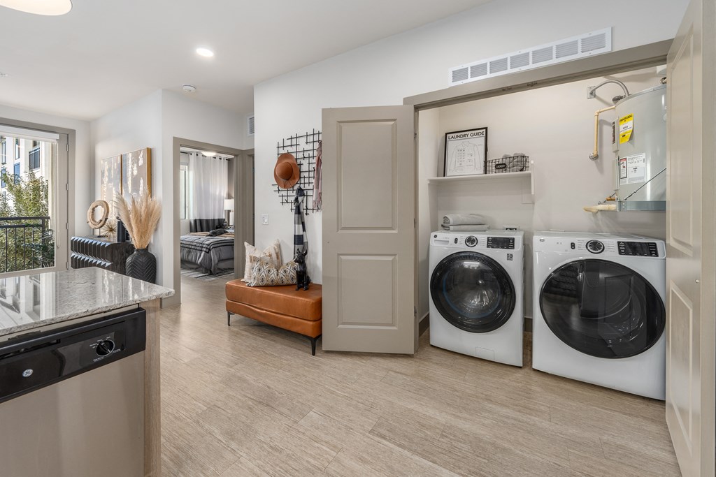 a washer and dryer in a laundry room with a sink and a door