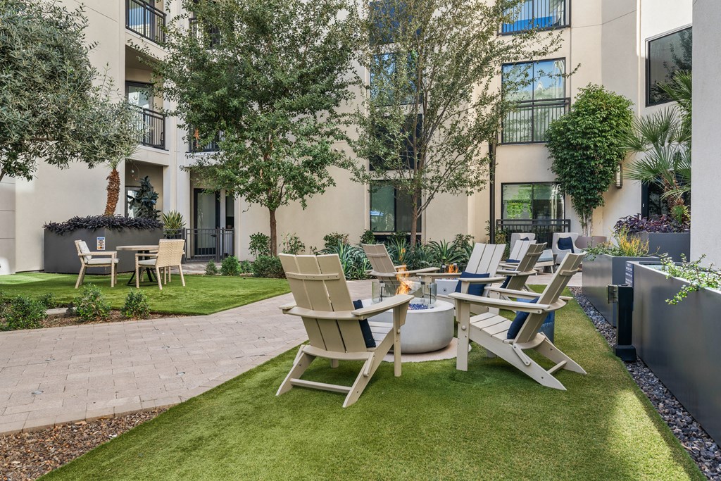 a patio with a table and chairs in front of an apartment building