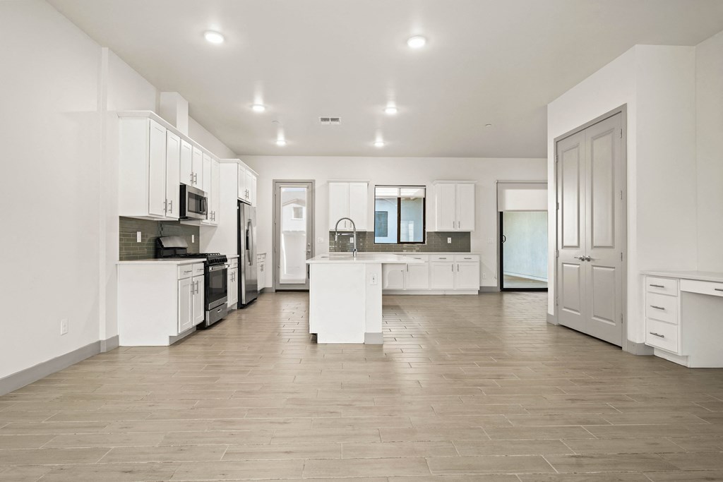 A spacious kitchen with white cabinets and a central island.