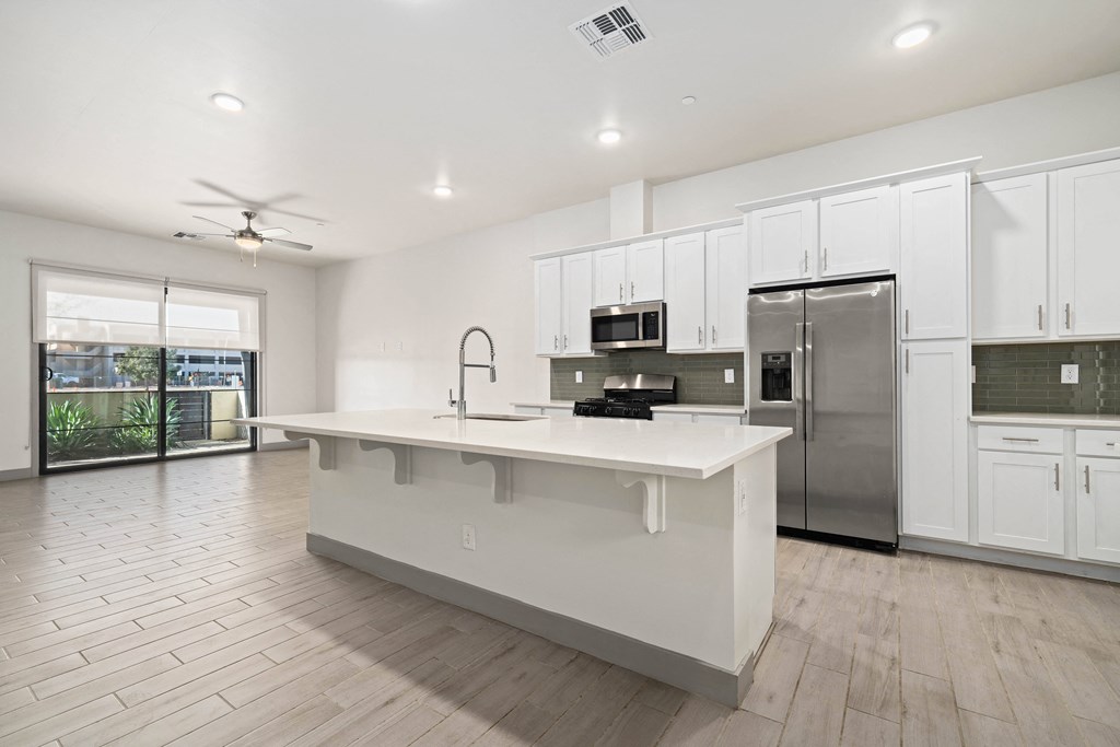 A modern kitchen with white cabinets and a large island.