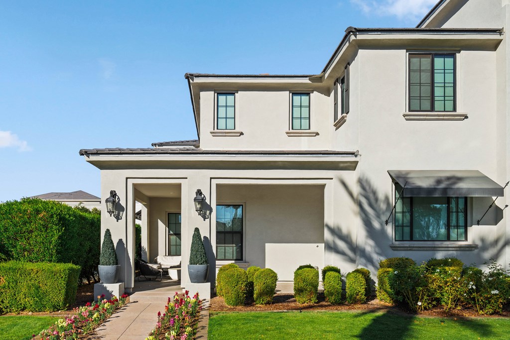 A modern house with a white exterior and a large front yard.