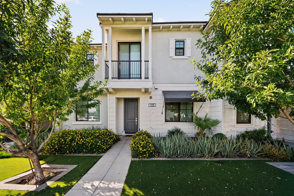 A two-story house with a balcony on the second floor.