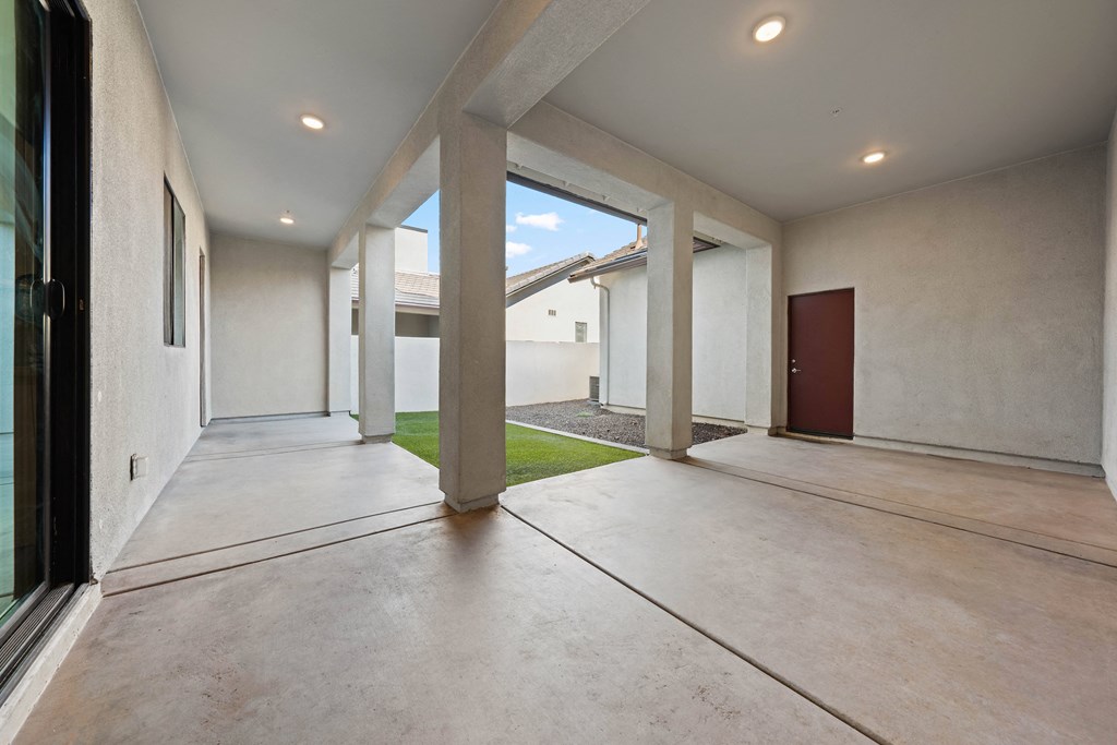 A long hallway with a door on the right and a window on the left.