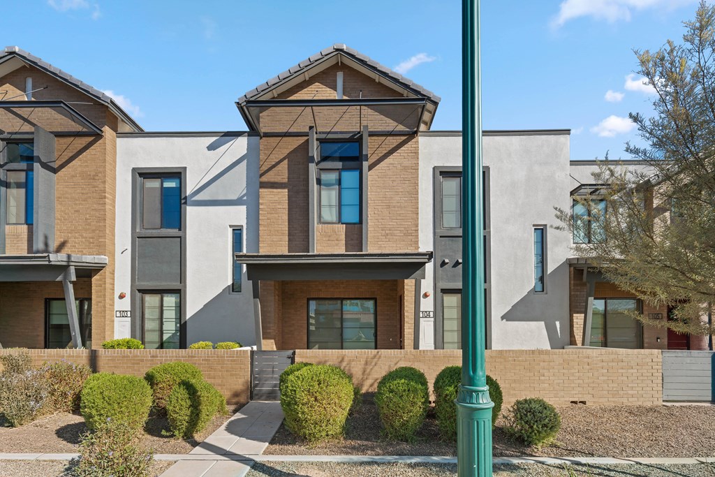 A modern house with a green pole in front.
