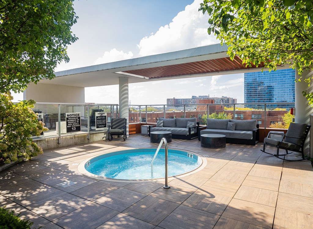 A pool with a hot tub in the middle of a patio.