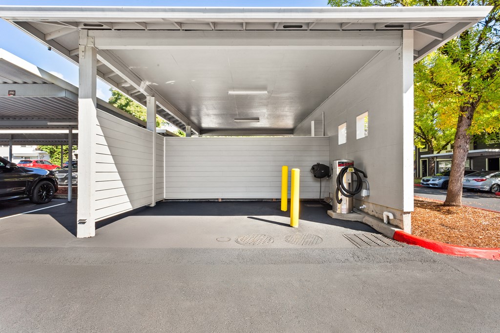 A car is parked under a covered parking structure.