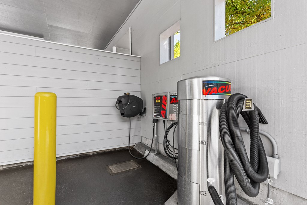 A yellow pole stands next to a vacuum cleaner in a room.